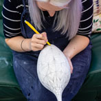 Rhian Malin decorating a mandala bottle in her workshop 2019